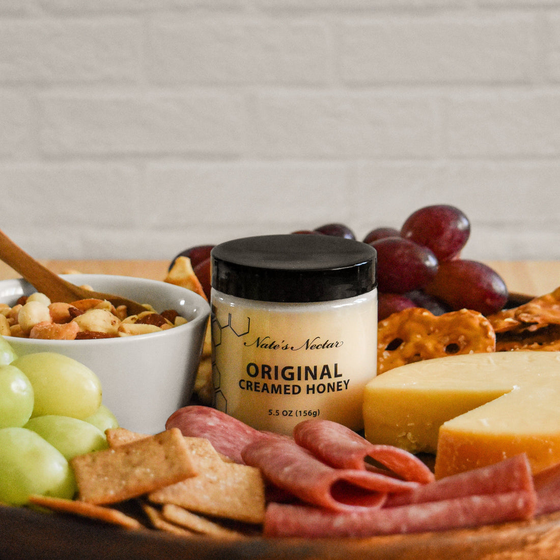 Nate's Nectar Original Creamed Honey on a charcuterie board