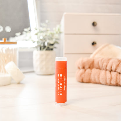 Bee Healed lip balm with white cap on a surface in a home setting