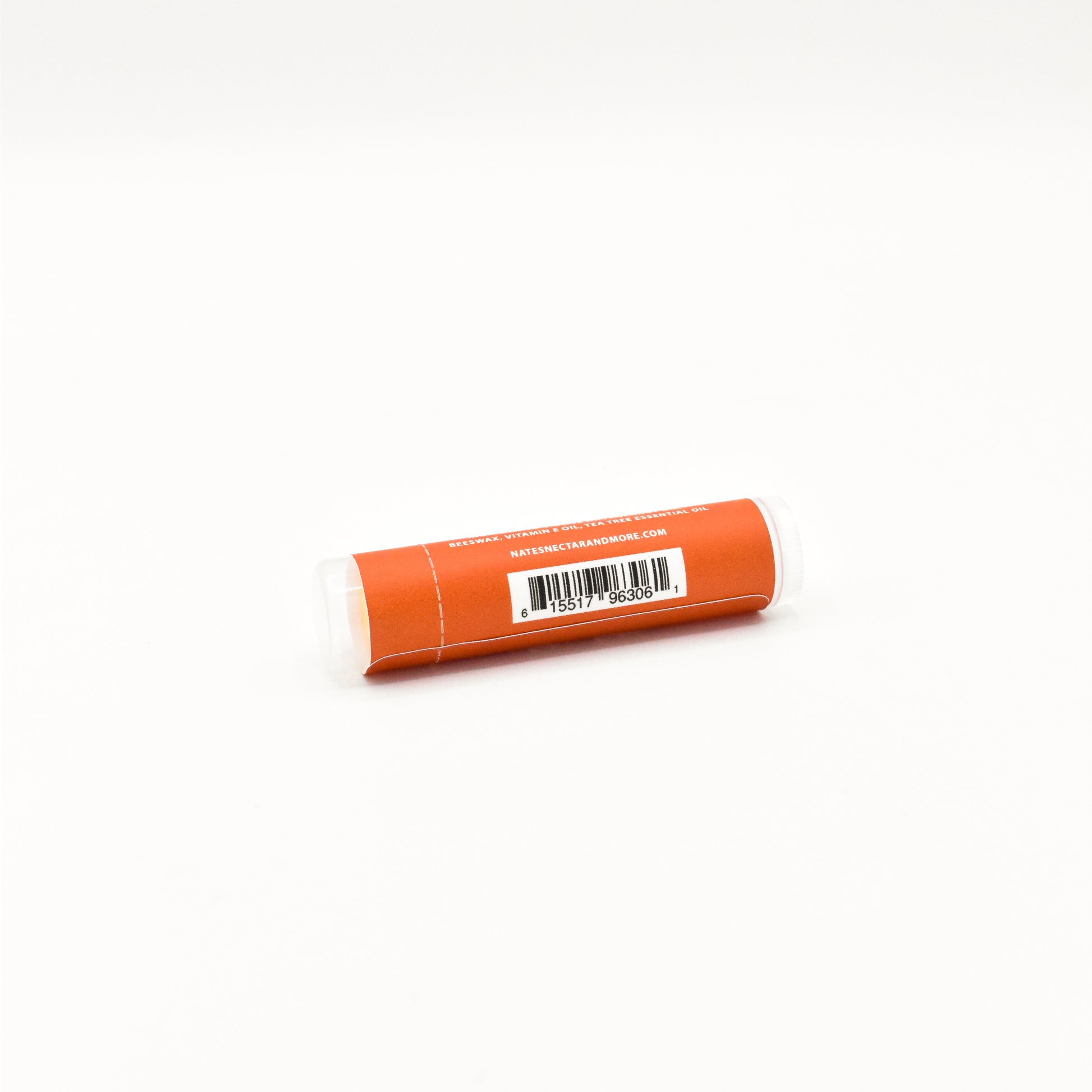 Orange lip balm with a white label on a white background
