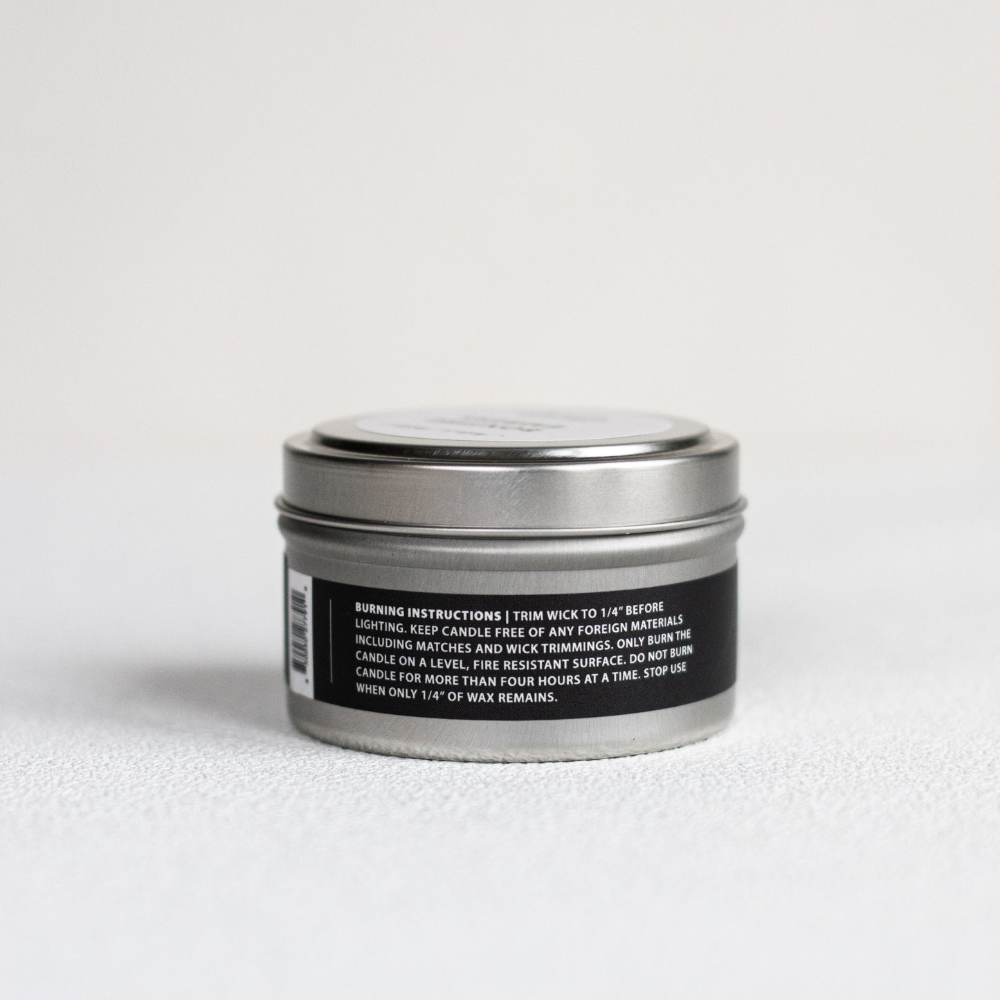 Candle tin with label on a light gray background