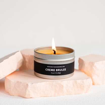 Candle in a tin labeled 'Creme Brèleé' on a light background