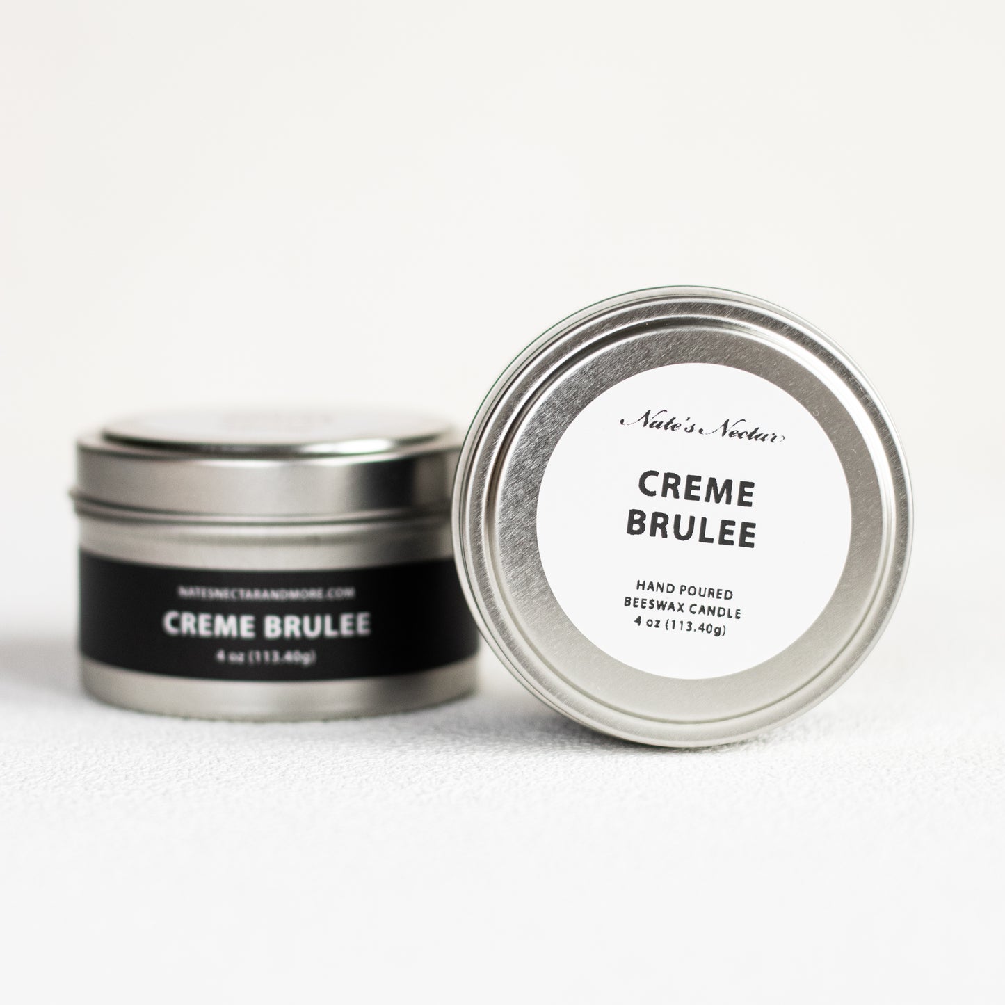 Creme Brèlee candle in a metal tin with a white label on a white background