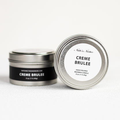 Creme Brèlee candle in a metal tin with a white label on a white background