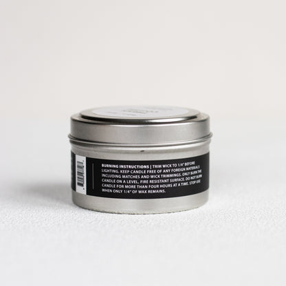 Silver candle tin with a black label on a white background