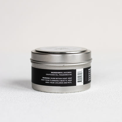 Silver candle tin with black label on a white background