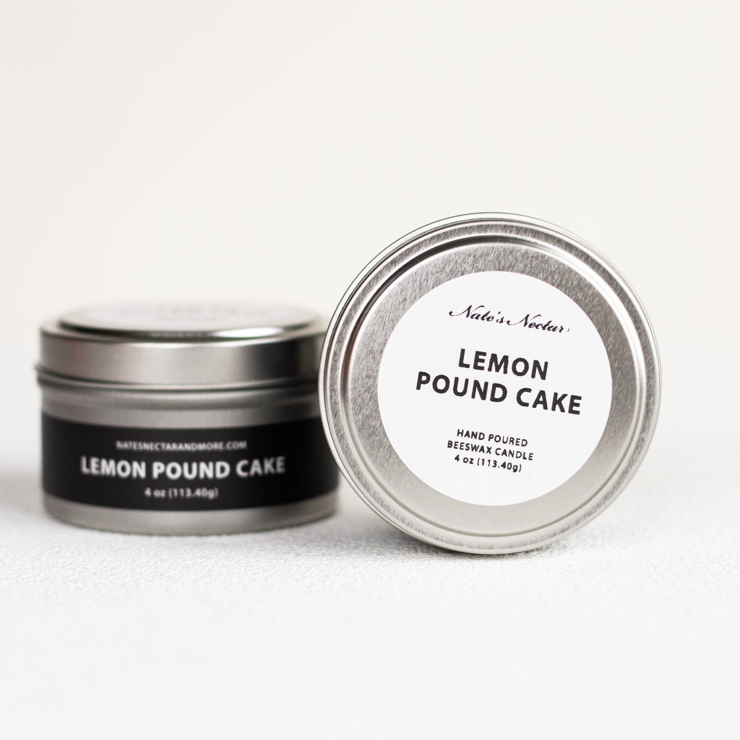 Two tins of 'Lemon Pound Cake' candle with labels on a white background