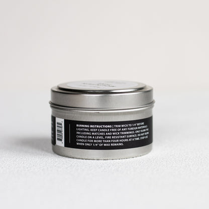 Silver candle tin with black label on a white background