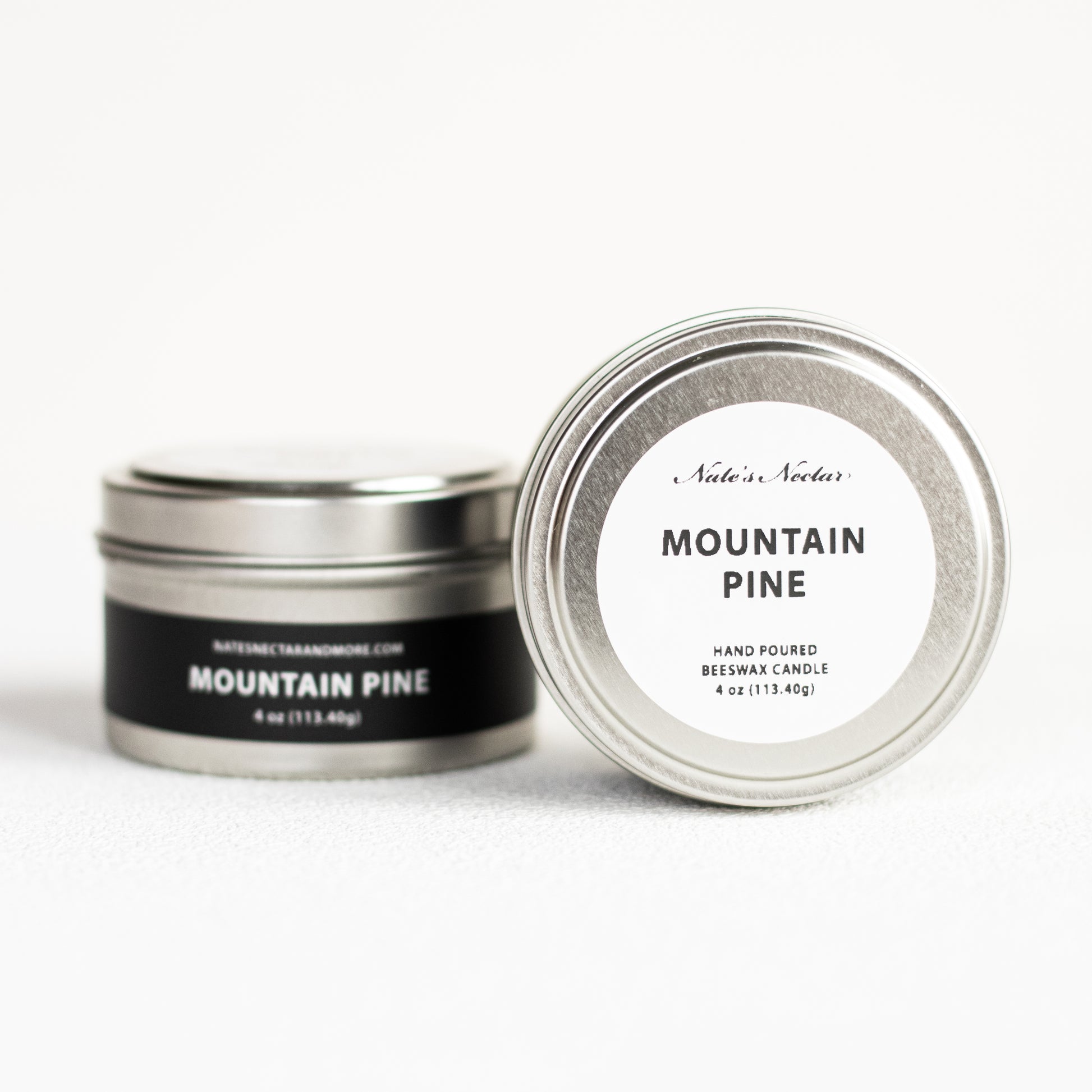 Two tins of 'Mountain Pine' candle with labels on a white background
