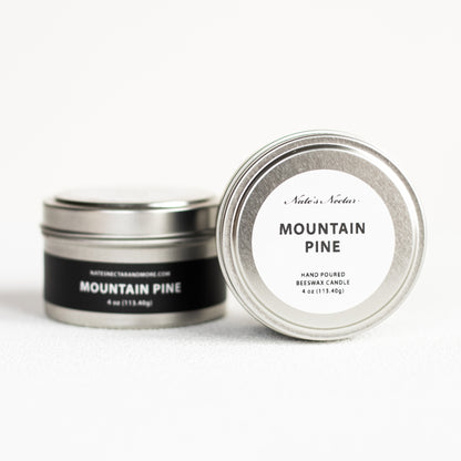 Two tins of 'Mountain Pine' candle with labels on a white background
