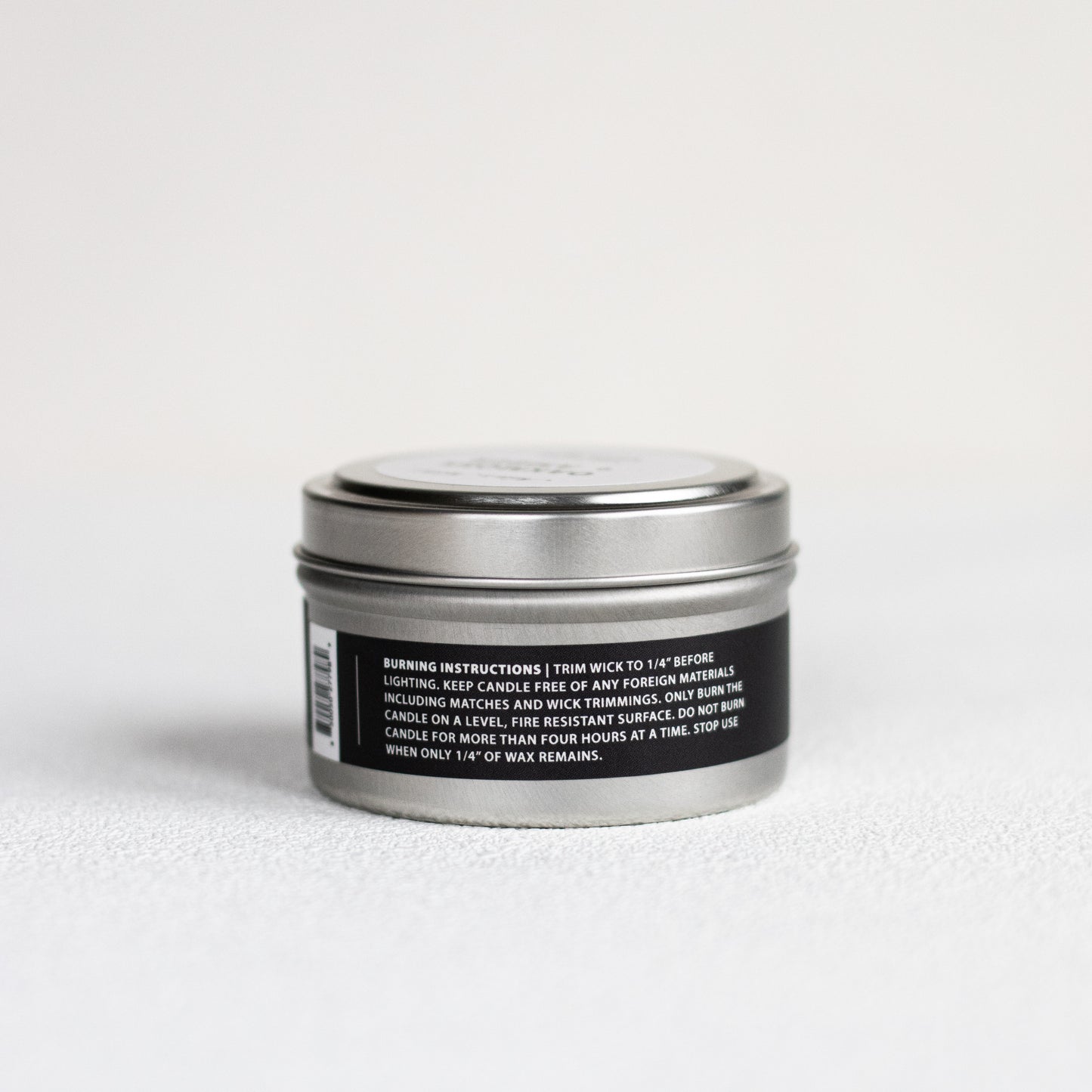Candle tin with label on a light gray background