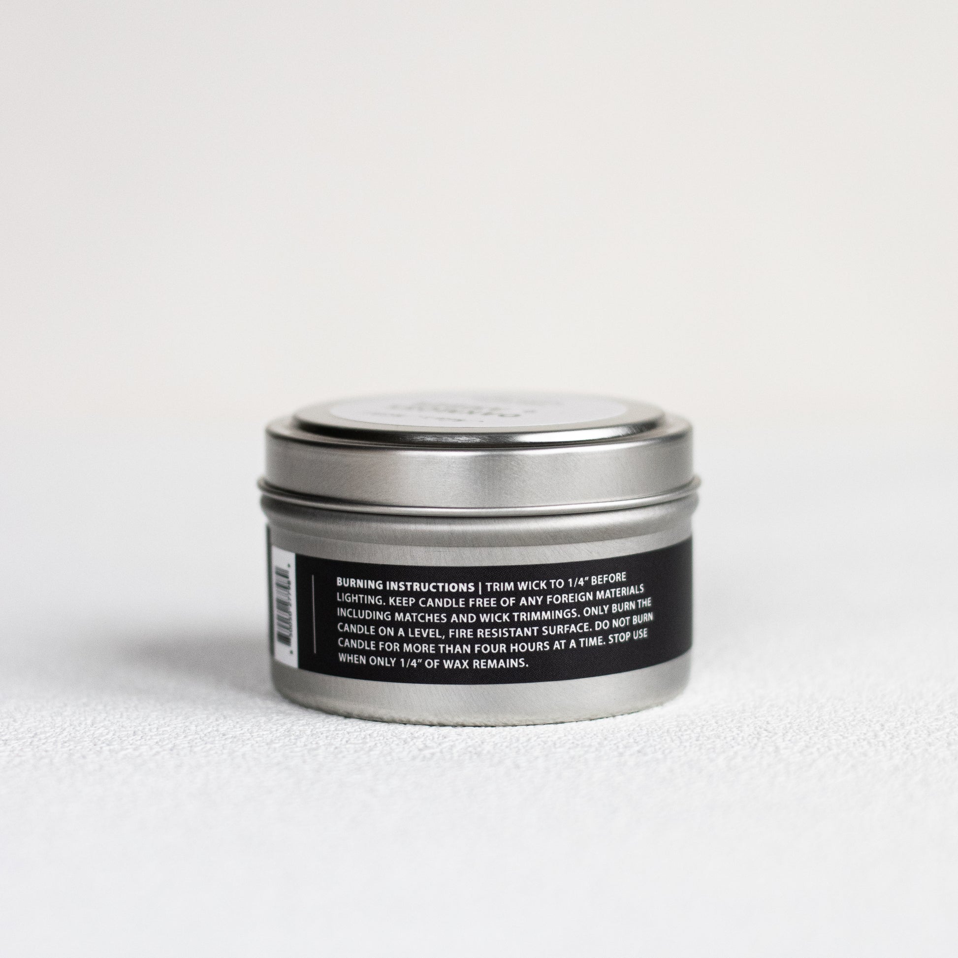 Candle tin with label on a light gray background