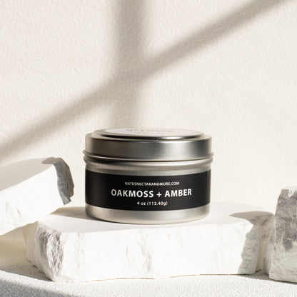 Silver tin labeled 'Oakmoss + Amber' on a light background