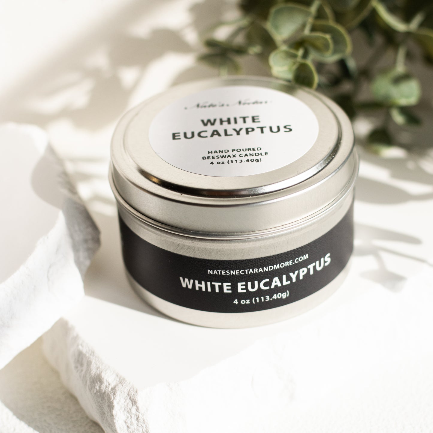 White Eucalyptus candle in a tin with a label on a white background