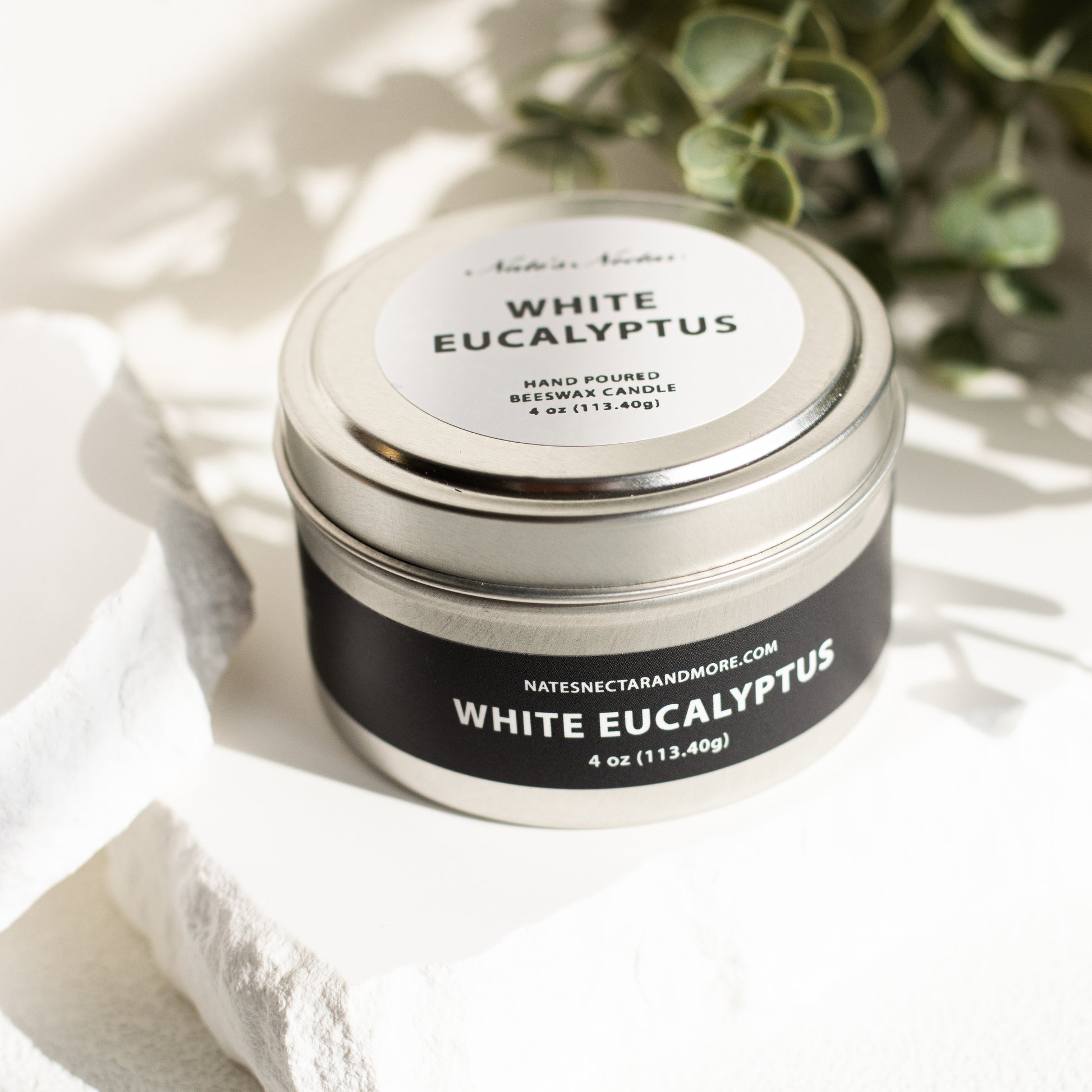 White Eucalyptus candle in a tin with a label on a white background