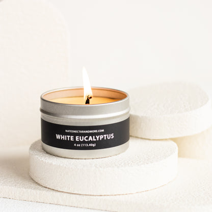Candle in a metal tin labeled 'White Eucalyptus' on a light background
