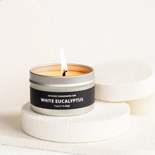 Candle in a metal tin labeled 'White Eucalyptus' on a light background