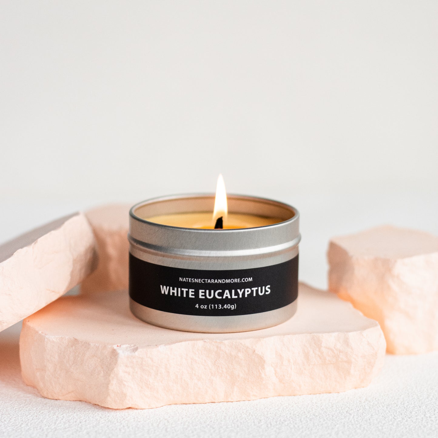 Candle in a tin labeled 'White Eucalyptus' on a light background