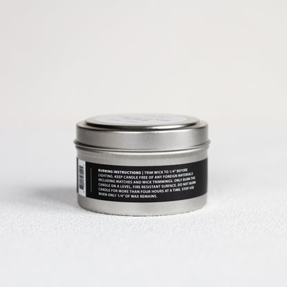 Silver candle tin with black label on a white background