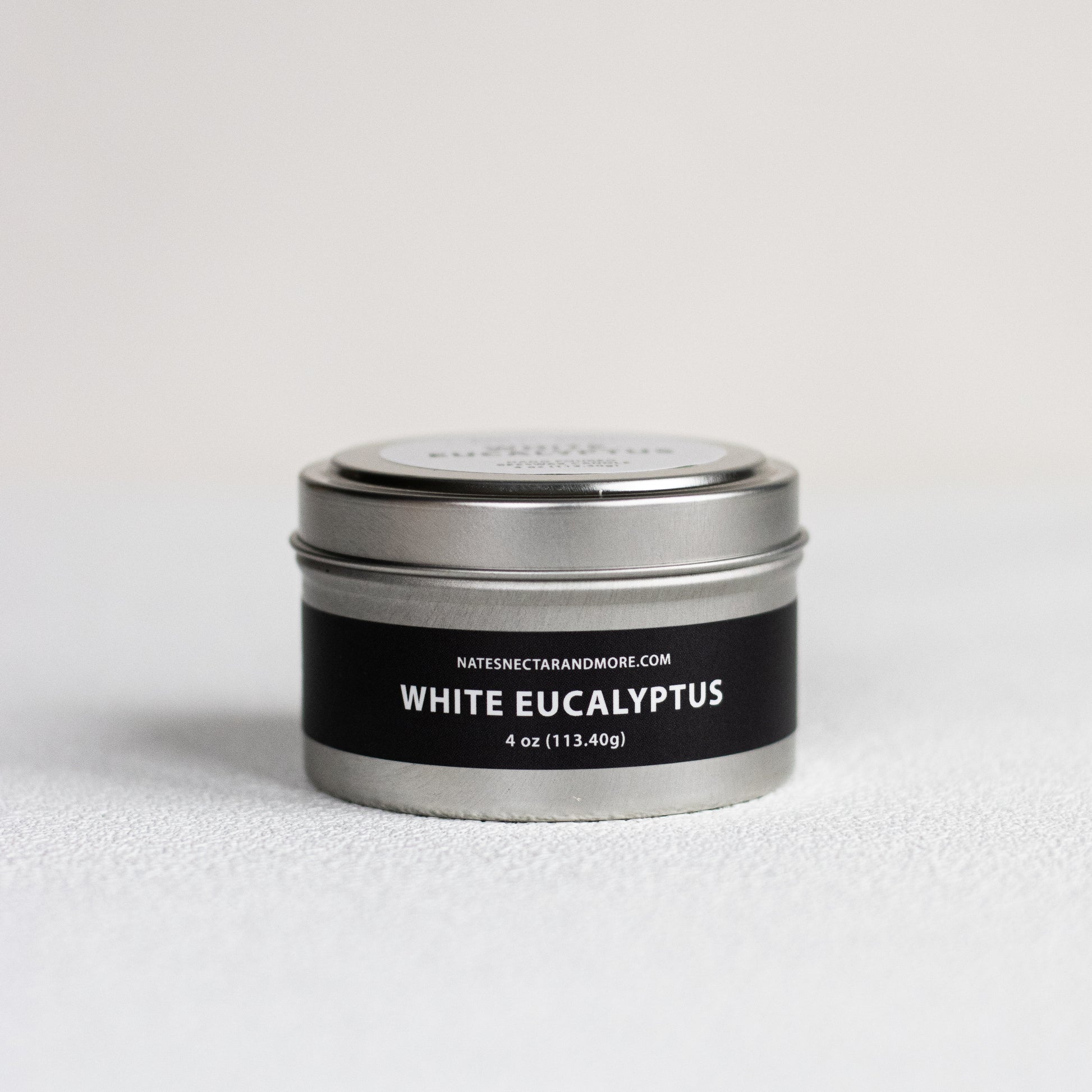 Candle tin labeled 'White Eucalyptus' on a light gray background